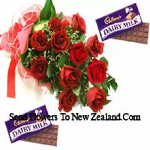 Bouquet de 11 roses rouges avec des garnitures saisonnières accompagnées de chocolats assortis Cadbury