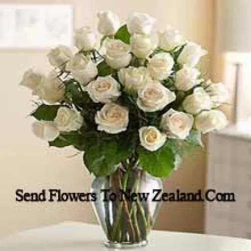 25 White Roses With Some Ferns In A Glass Vase