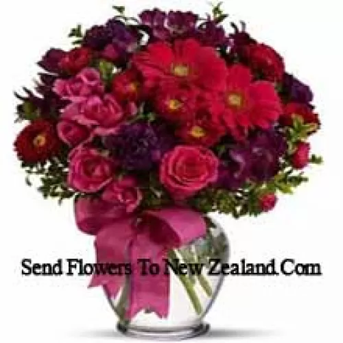 Roses roses, géraniums rouges et autres fleurs assorties disposées magnifiquement dans un vase en verre - 37 tiges et remplissages