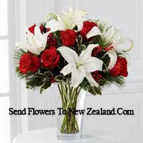 Fulfill their dreams for a glimpse of the season's inspired beauty. Rich red roses dazzle and delight when arranged with snowy white Oriental lilies accented with assorted holiday greens and variegated holly stems in a clear, sculpted glass vase. This bouquet offers them a warm wish for a lovely holiday season they will always hold dear. (Please Note That We Reserve The Right To Substitute Any Product With A Suitable Product Of Equal Value In Case Of Non-Availability Of A Certain Product)